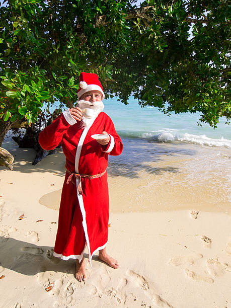 istock man dressed as Santa Claus sipping coffee on tropical beach 526445297