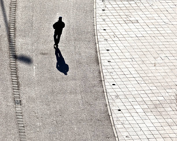 istock people walking at the street with long shadows 526445641