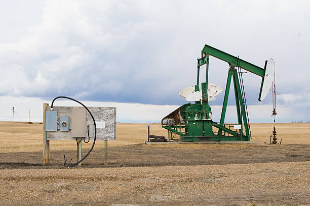 pumpjack in alberta, canada - oil pump oil industry prairie field foto e immagini stock