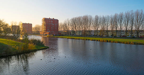 una torre alta que está ubicada junto al río al atardecer de otoño - almere fotografías e imágenes de stock