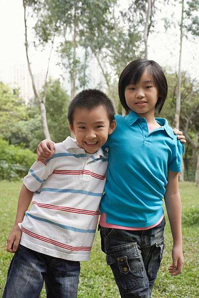 istock Siblings Standing Arms Around In Park 526466847