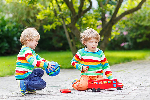 istock Two siblings, kid boys playing with red school bus 526470769