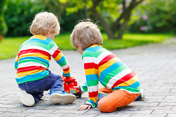 istock Two siblings, kid boys playing with red school bus 526470773