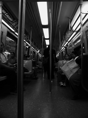 New York City, NY, USA - May 11, 2002: Commuters head to their destination on the F train. Asian family to right. Hispanic man and woman to left. 