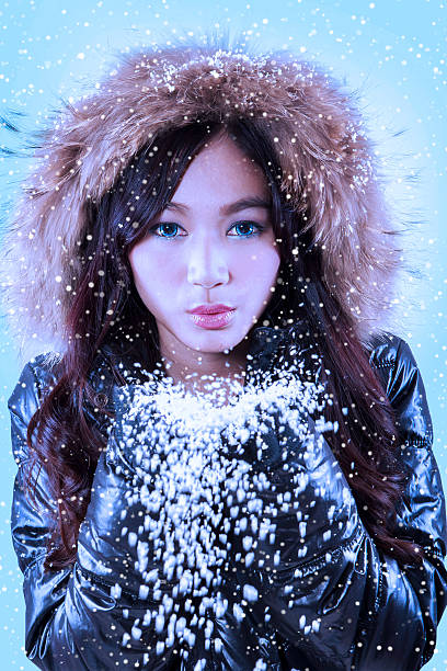 A beautiful girl in the image of a white swan in a silver dress with white feathers in the hands of the Snow Queen. Portrait of a luxurious blonde. Creative hairstyle and makeup. blue eyes.