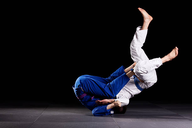 Brazilian jiu-jitsu martial arts Two jiujitsu wrestlers sparring in combat during the sport training. One fighter is throwing the other up over his head. wrestling sport stock pictures, royalty-free photos & images