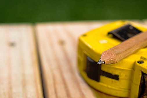 Carpenter's Pencil and Measureing Tape sitting on a newly contructed outdoor deck constructed with 2X6 Pressure Treated Southern Yellow Pine, this dimensional lumber typically used for residential decking and other outdoor projects.