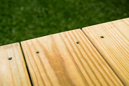 Looking down on the edge of Pressure Treated Wood deck, made from 2X6 Pressure Treated Southern Yellow Pine, typically used for residential decking and other outdoor projects.