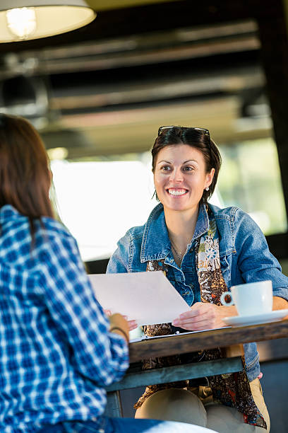 Mature woman having meeting with client in coffee shop Mature woman having meeting with client in coffee shop casual job interview stock pictures, royalty-free photos & images