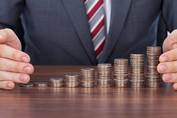 istock Businessman Protecting Coin Stacks At Desk 526494467