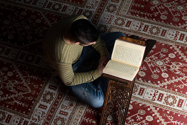istock Young Muslim Guy Reading The Koran 526495331