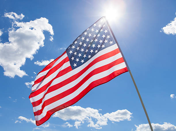 istock USA flag waving on blue sky background 526496783
