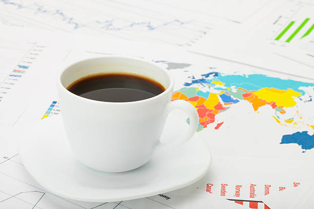 istock Cup of coffee over world map and financial documents 526504149