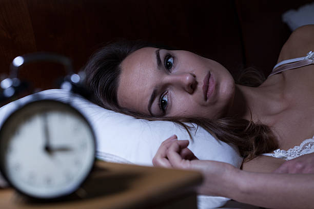 Insomnia Woman lying in bed suffering from insomnia woman sleeping in bed at night stock pictures, royalty-free photos & images