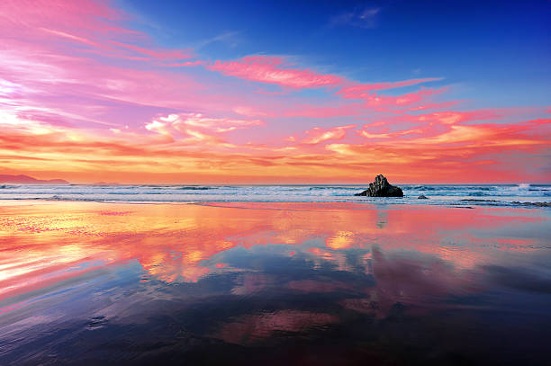 sopelana beach at sunset with clouds reflections sopelana beach at the sunset with clouds reflections sopelana stock pictures, royalty-free photos & images