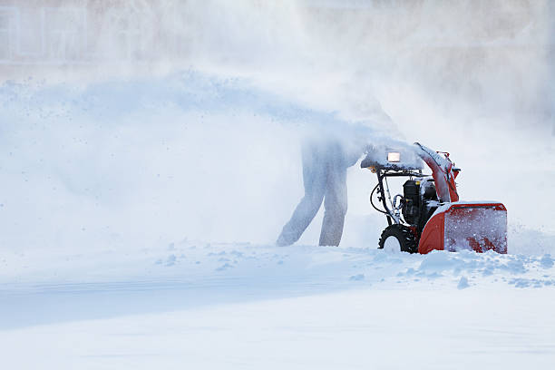 man with a snow blowing machine man with a snow blowing machine working in winter day deep snow stock pictures, royalty-free photos & images