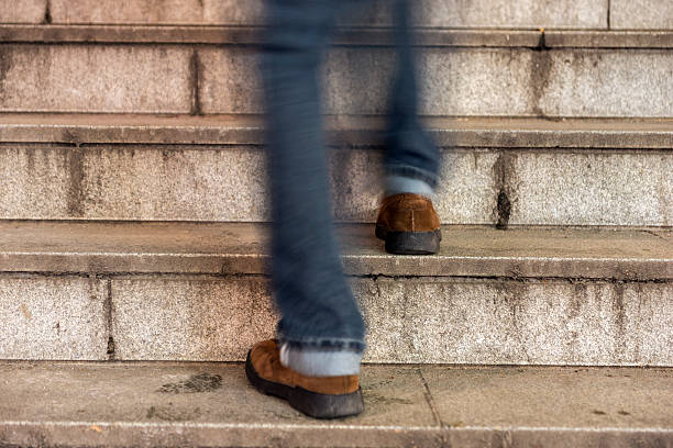 istock man walking up an old stone staircase 526508977