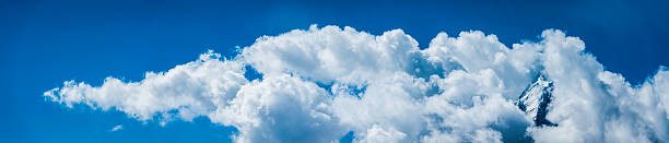 istock Snowy mountain peak appearing through blue sky cloudscape panorama Himalayas 526510011