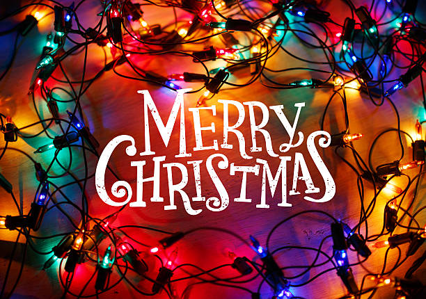 Christmas lights frame on wood background with Merry Christmas lettering.