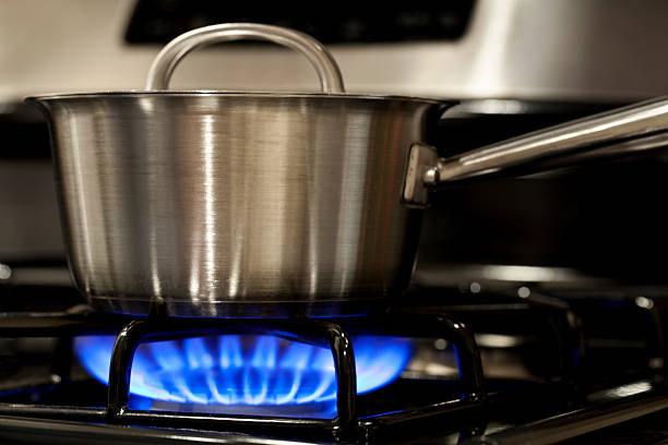 istock Stainless steel  pot on stove with blue natural gas flame 526532165