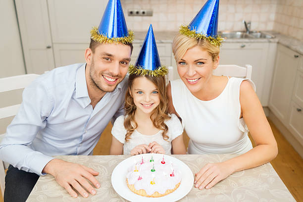 istock smiling family in blue hats with cake 526532349