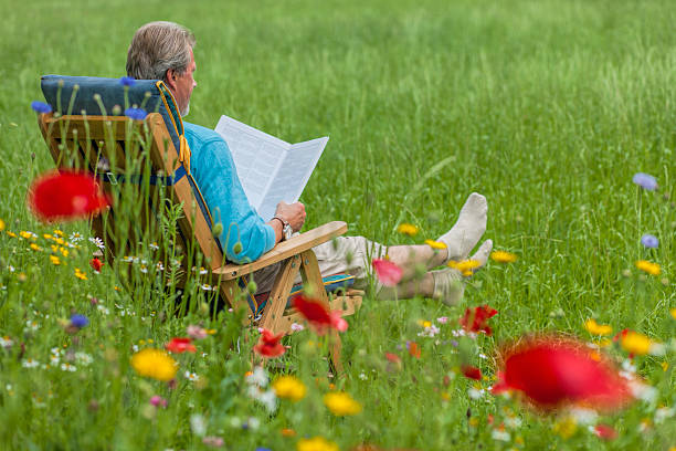 istock Senior man sitting on deck chair in garden 526534235