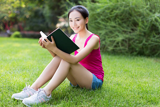 istock asian pretty women in the park with book 526537617