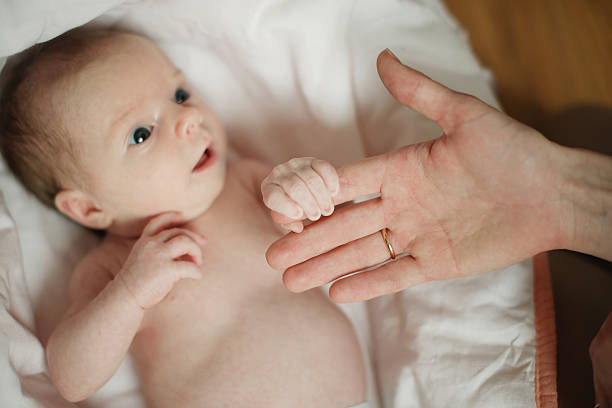 istock little baby keeps mom's fingers 526538077