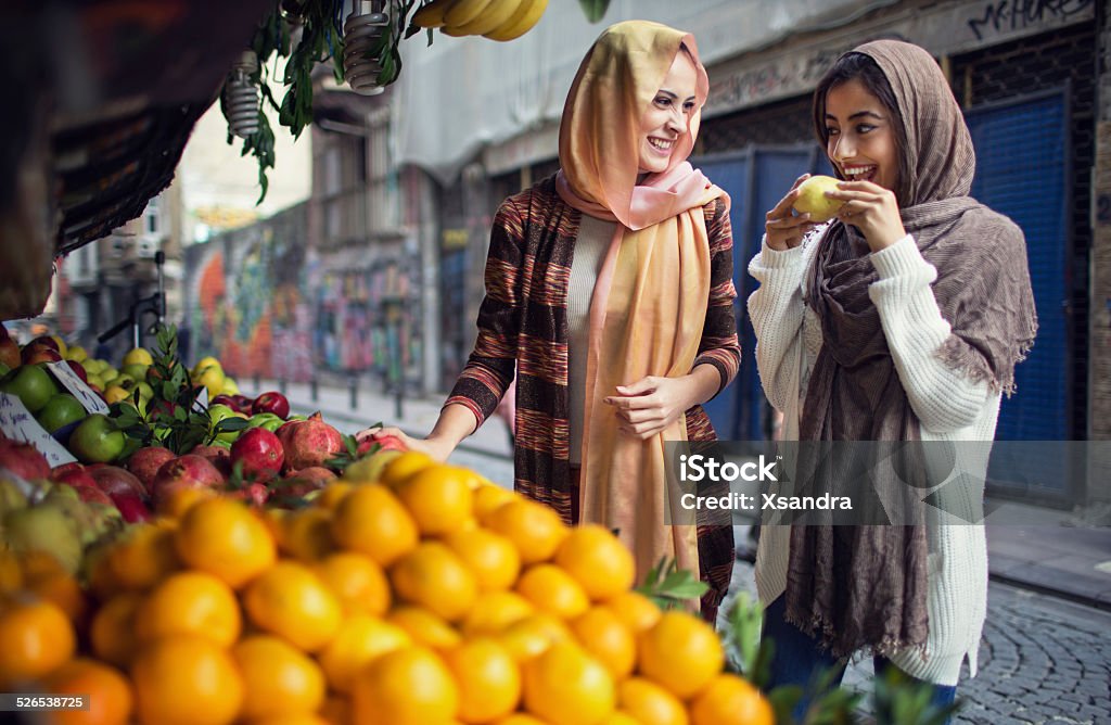 Women buying fruits from the street vendor Two Turkish women buying fruits from the street vendor. Market - Retail Space Stock Photo
