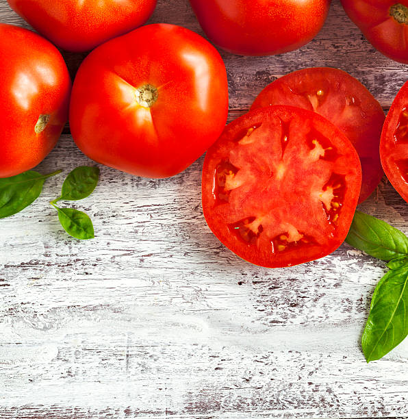 istock Fresh tomatoes and basil on wooden background 526539022