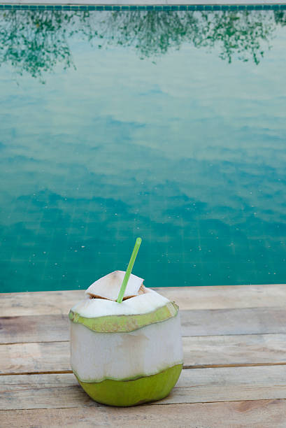 istock Coconut drink on wooden table at swimming pool 526539580