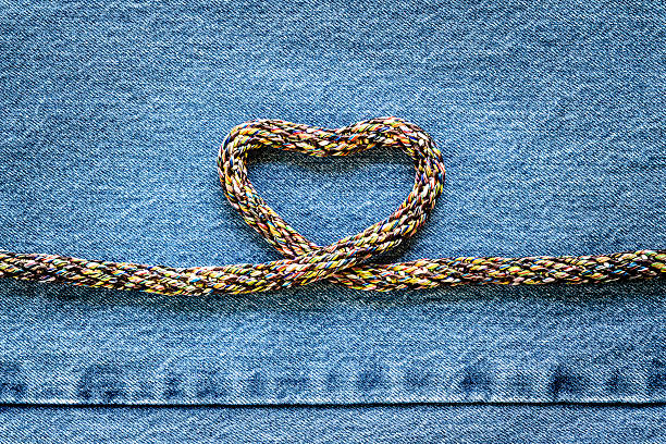 istock Love heart shaped rope on denim jeans background 526541770