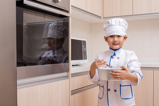 Asian Chinese Boy in white chef uniform Baking Cookies at Home