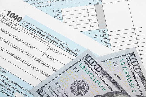 istock Tax Form 1040 with two 100 dollars banknotes 526544665