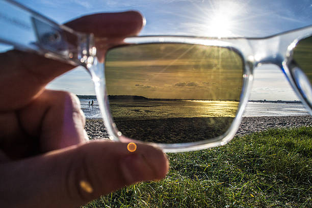 polarisierte sonnenbrille mit blick auf den hafen, das meer und den strand. - polarizer stock-fotos und bilder