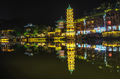 fenghuang, phoenix ancient town, night view with reflections of the town on the river