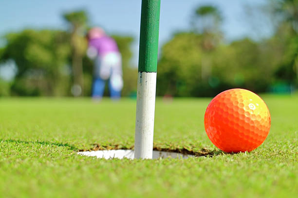 istock Closeup golf hole and ball on green grass golf course. 526546600