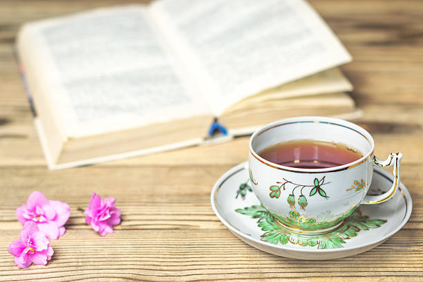 istock Tea cup, the book and flowers on the wooden table 526548234