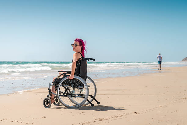 behinderte frau am strand - men chair wheelchair sport stock-fotos und bilder