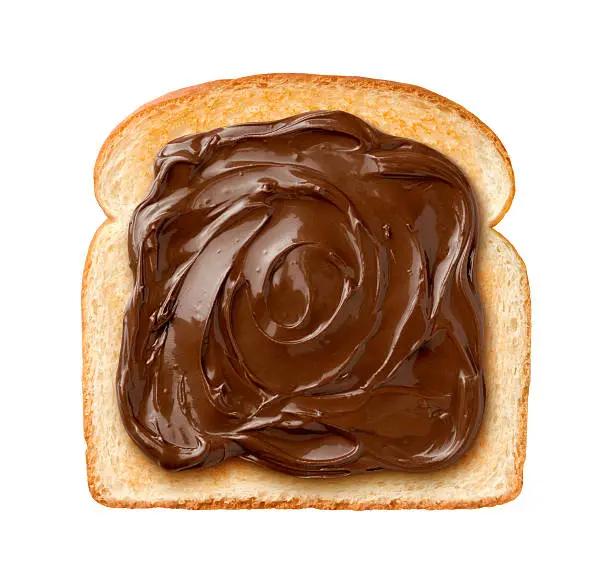 Aerial view of Chocolate Spread on a single slice of Toast.  Some chocolate spreads come from  the brand name Nutella.  The spread is laid out in and artistic manner resembling scrollwork.  The bread is lightly toasted.  The image is isolated on a white background.