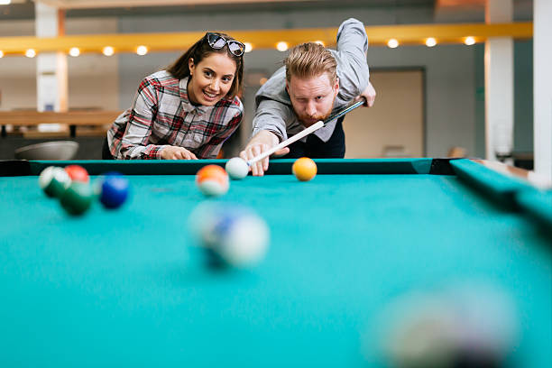 istock Beautiful couple playing billiards 526554730