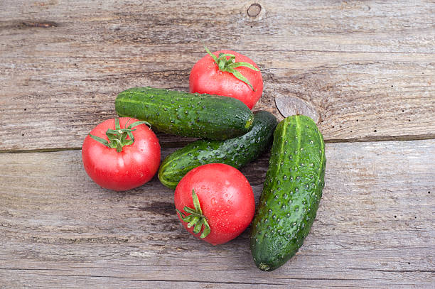 istock Tomatoes and cucumbers on wooden background 526555836