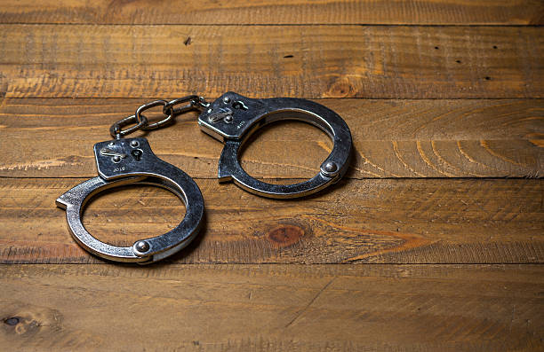 istock Handcuffs on a wooden table 526556382