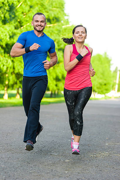 istock Runners training outdoors working out. City running couple jogging outside. 526558808