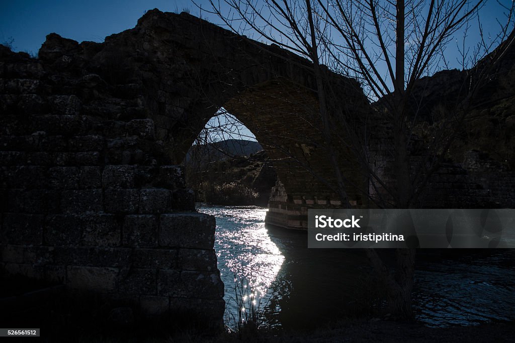 Silhouette of the ruins of a bridge Landscape of a backlit bridge in ruins in Catalonia, Camarassa, the river Segre Aqueduct Stock Photo