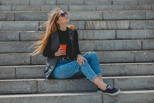 istock Young girl sitting on the steps with coffee in glasses. 526564262