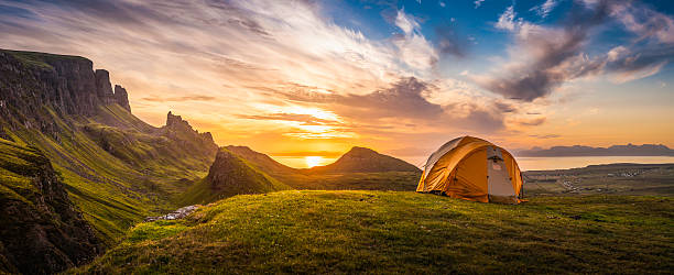 Golden sunrise illuminating tent camping dramatic mountain landscape panorama Scotland Dome tent illuminated by the warm glow of sunrise as a golden cloudscape reveals the dramatic mountain pinnacles of this panoramic landscape. ProPhoto RGB profile for maximum color fidelity and gamut. scottish highlands photos stock pictures, royalty-free photos & images