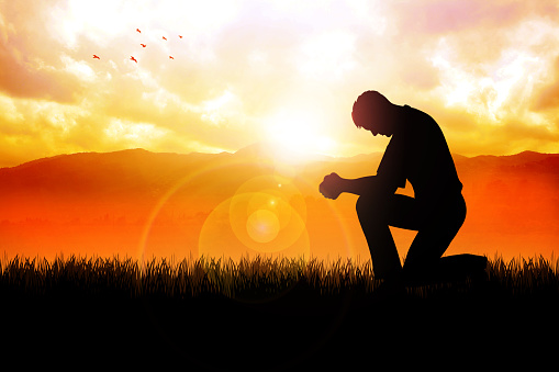Silhouette illustration of a man praying outside at beautiful landscape