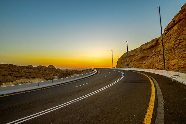 Road and Sunset, Al Ain Beautiful sunset captured during my road trip to Jebel Hateef Mountaing Al Ain, UAE. It well known that UAE it's basically only desert without hills and mountains, but this is a beautiful one in Al Ain, and its a must visit place if you are traveling to UAE. The sunset is amazing there. It looks kind like Mars, as we see in the movies. jebel hafeet stock pictures, royalty-free photos & images