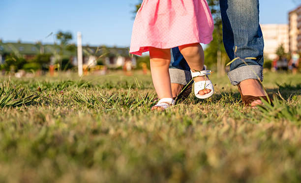 istock Baby girl learning to walk over a grass park 526568255